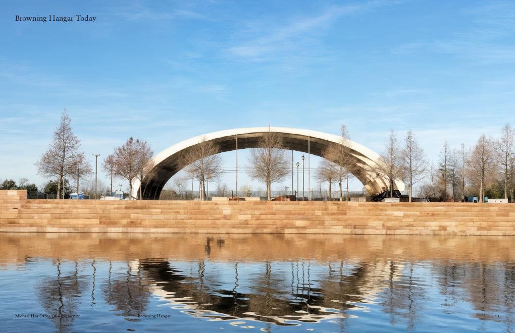 Architect's photo of the Hangar today from Mueller Lake: a single open arch reflected in the water.