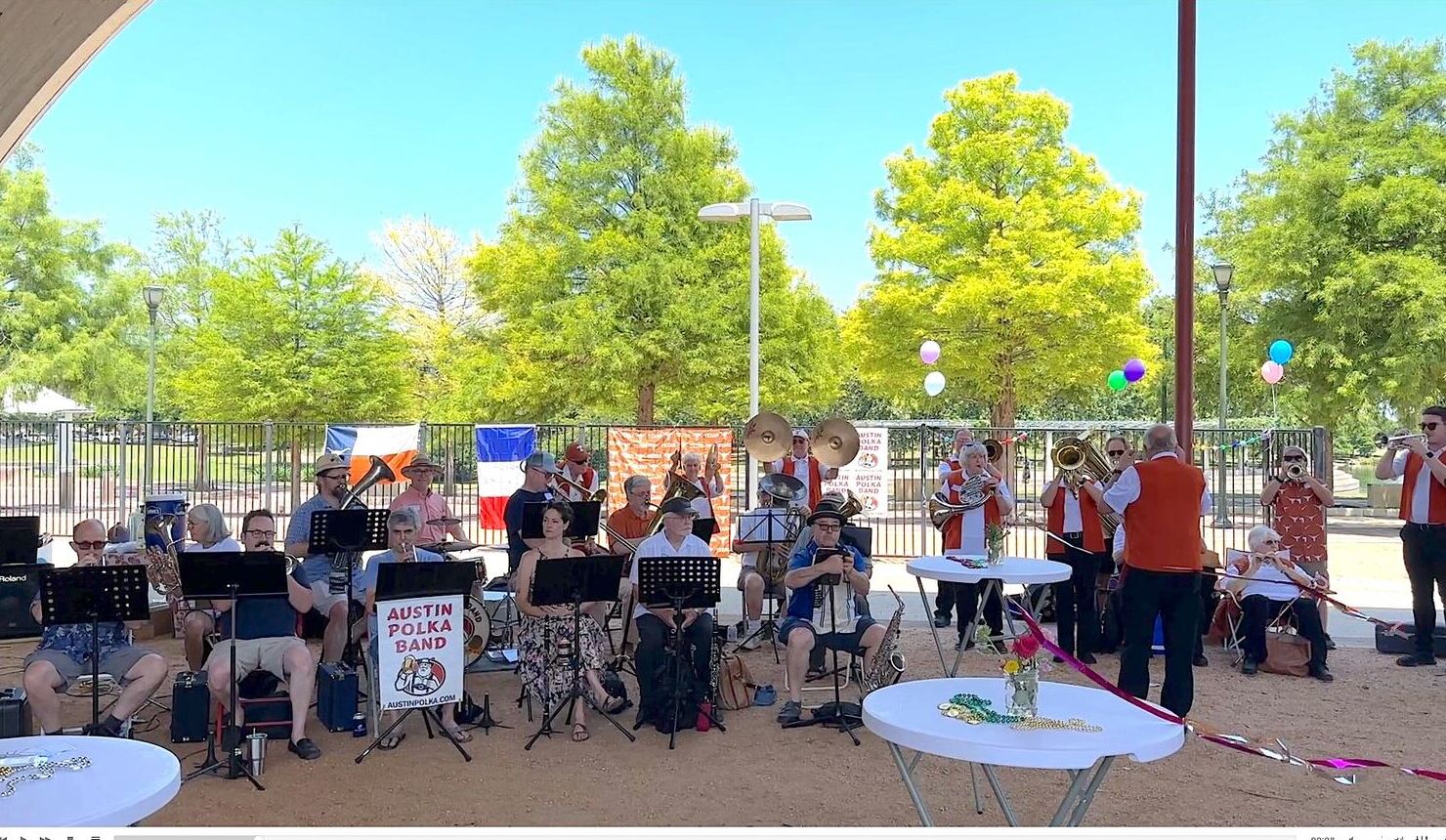 A polka band with brass instruments performing at the edge of the Hangar.
