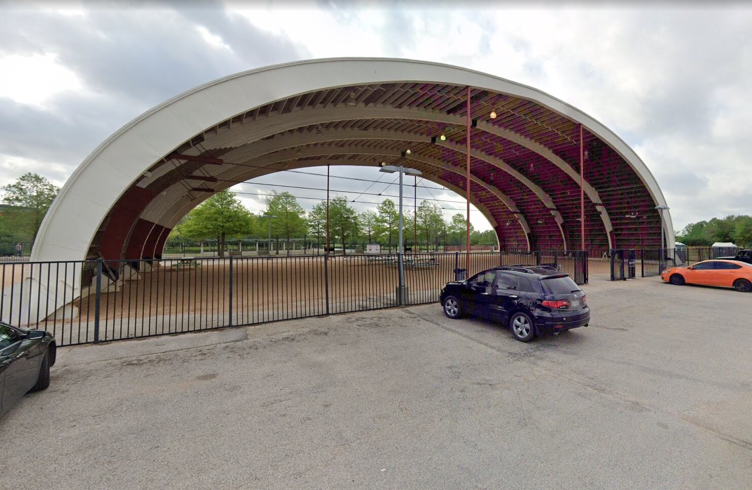 The Hangar seen from the parking lot, with a metal fence along its west side.